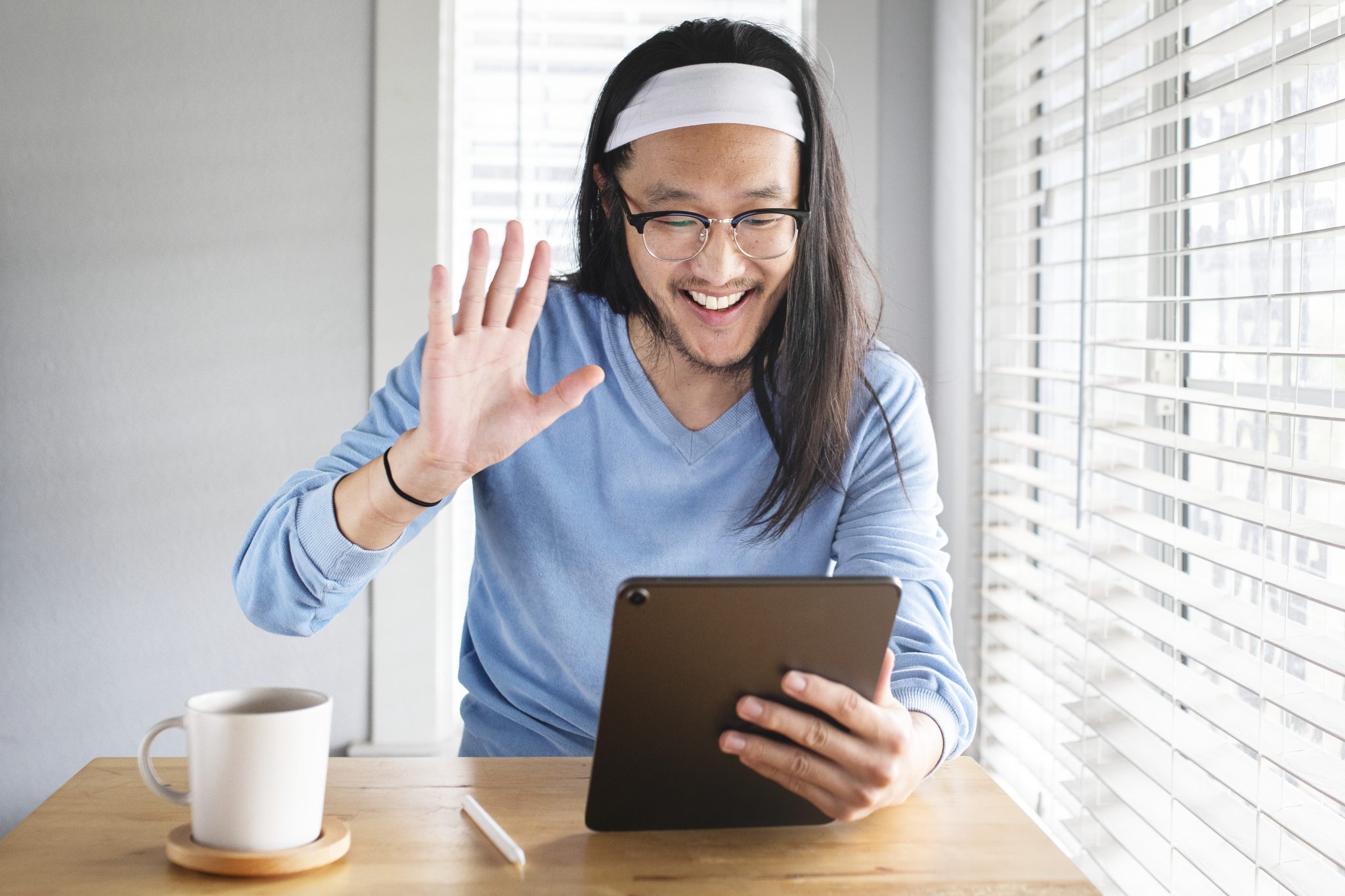 man waving hello on video call