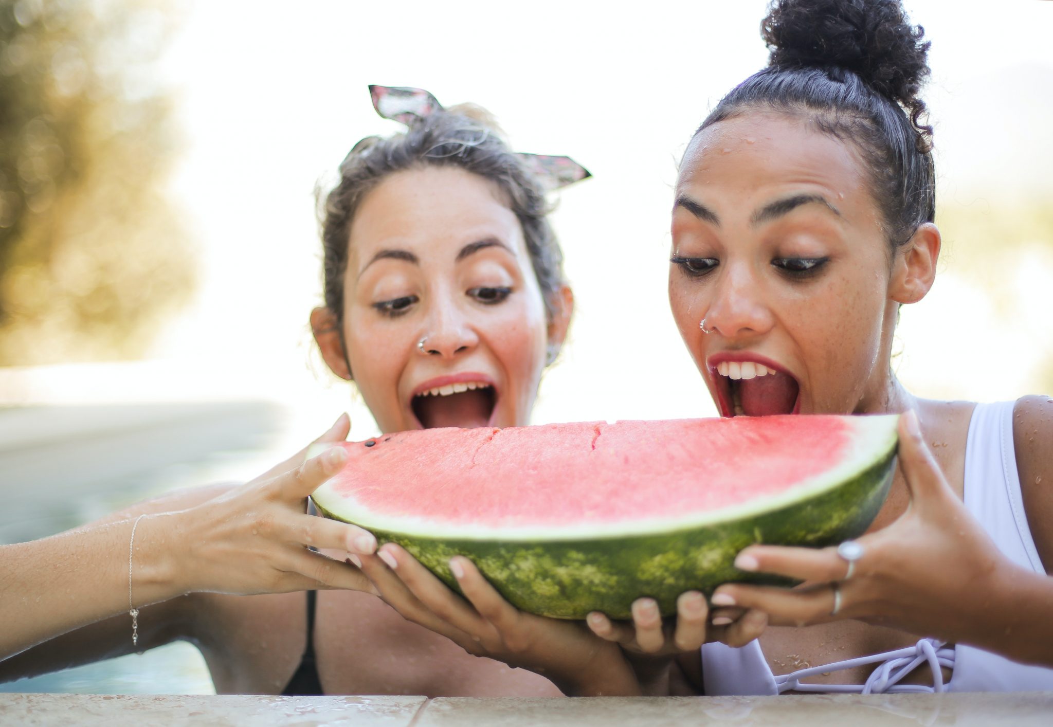 two women eating a watermelon slice