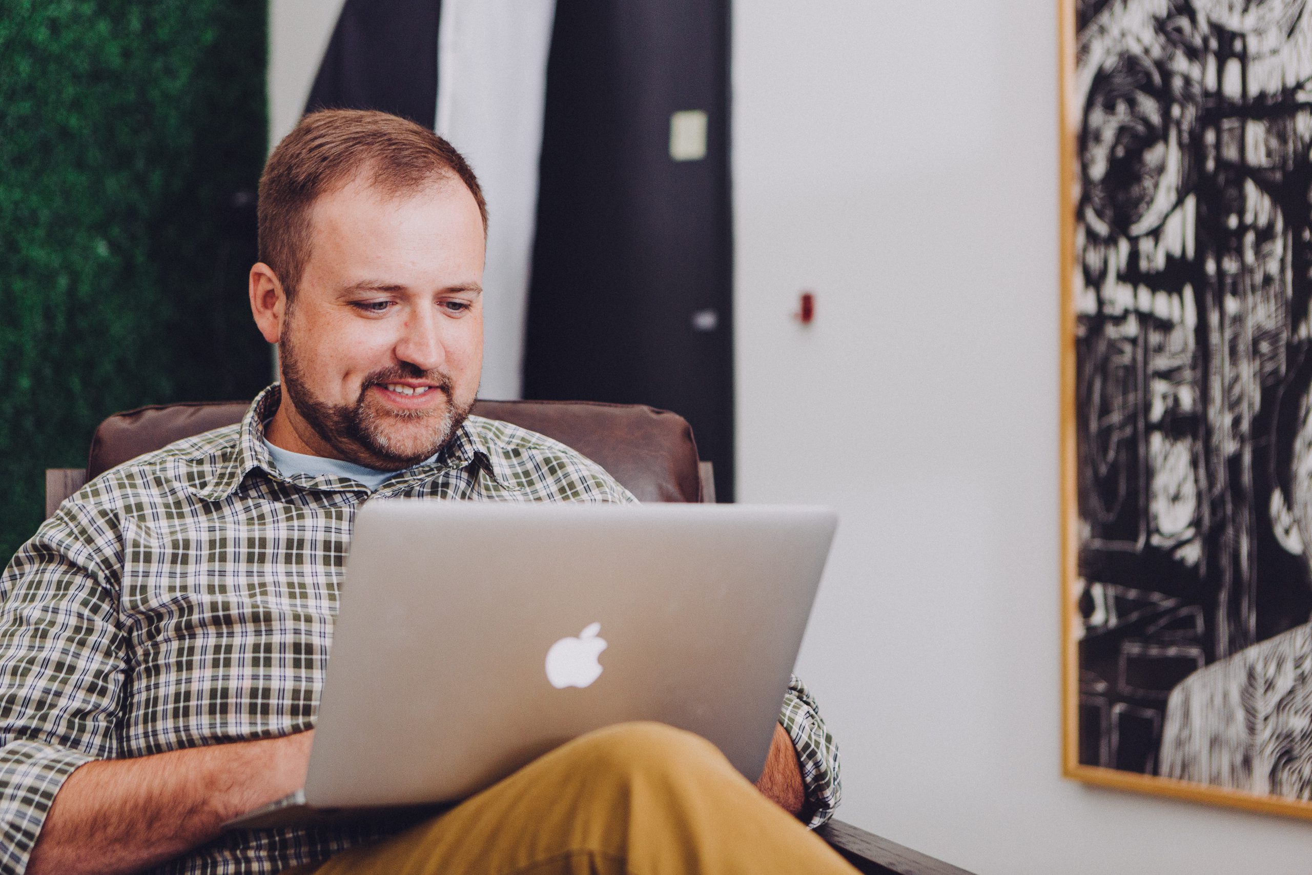 man smiling while using MacBook