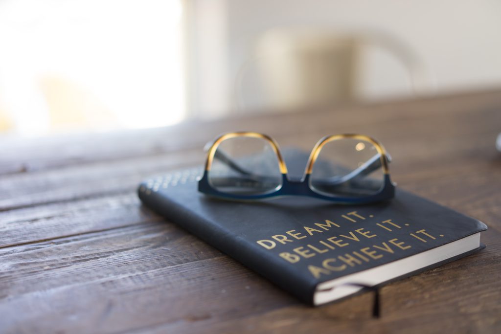 notebook with glasses on a table