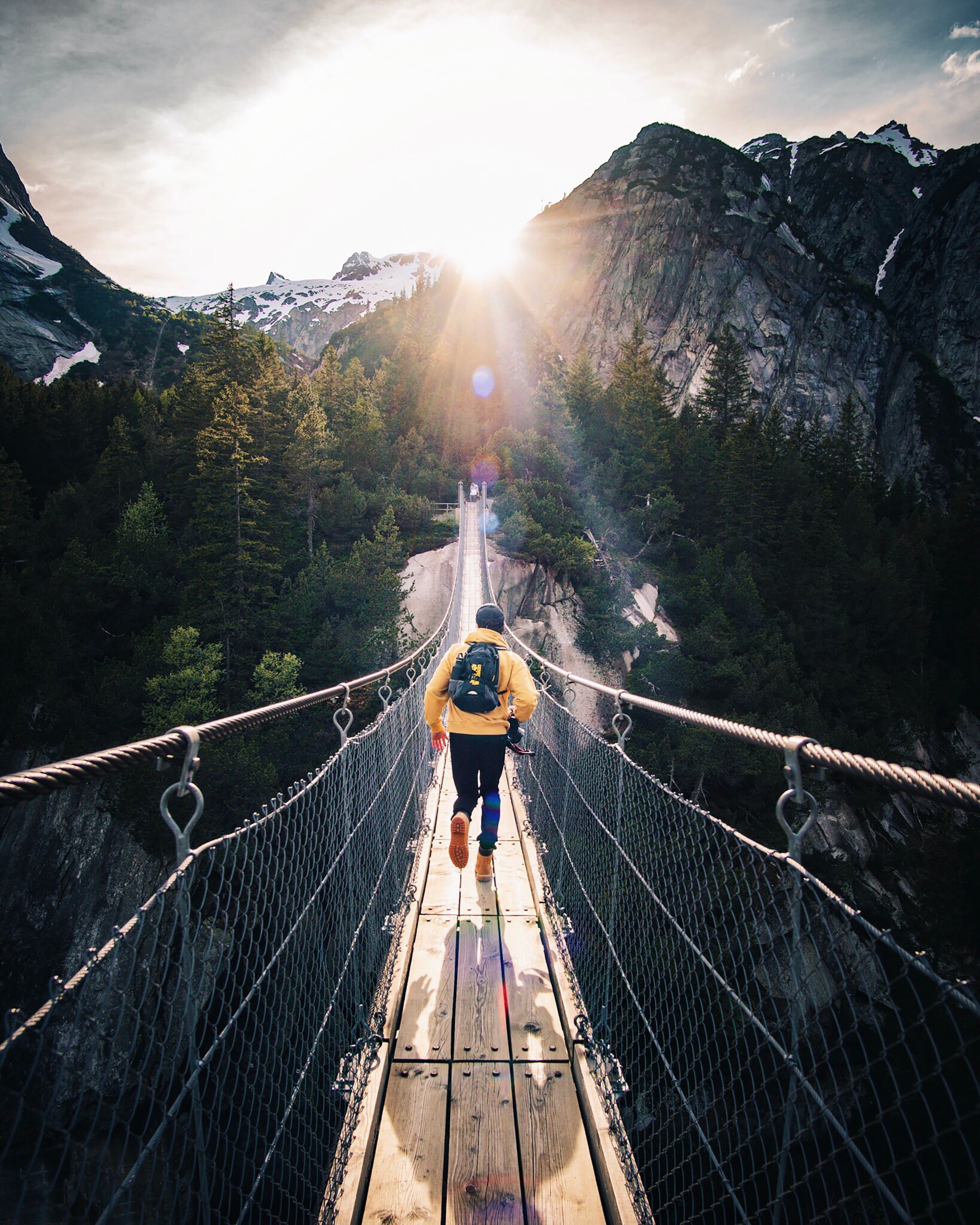 man running towards mountains on a bridge